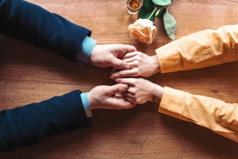 Love couple hands on wooden background